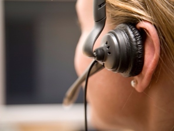Woman in call centre wearing ear phone device for calling